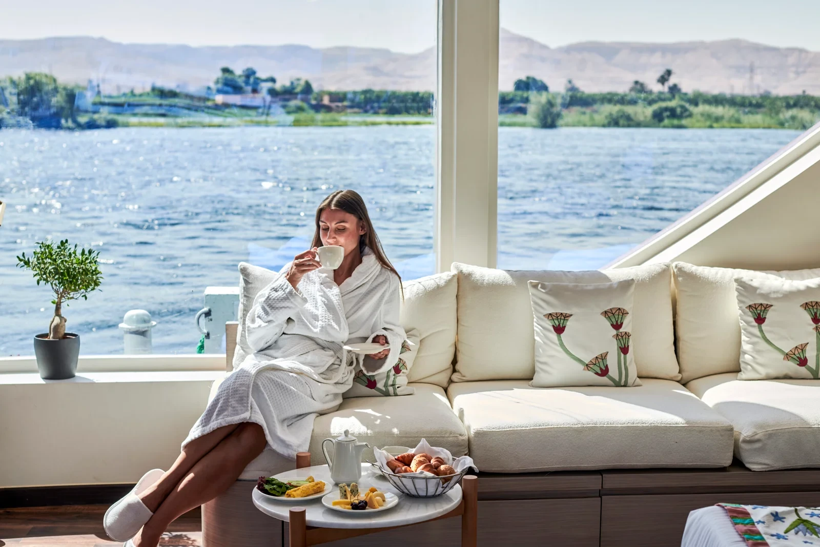 Traveler enjoying the scenic Nile River view in a Dahabiya